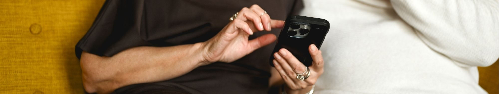 An elder adult couple is looking at a phone with concer